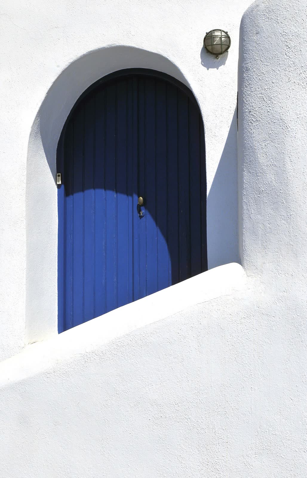 Whitewashed wall and blue door in Santorini